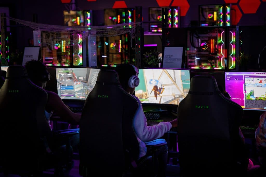 Gamers sat at desks playing Fortnite.