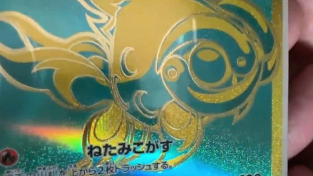 A Pokemon TCG player shows of the Secret Rare Chi-Yu card with embossed gold foil