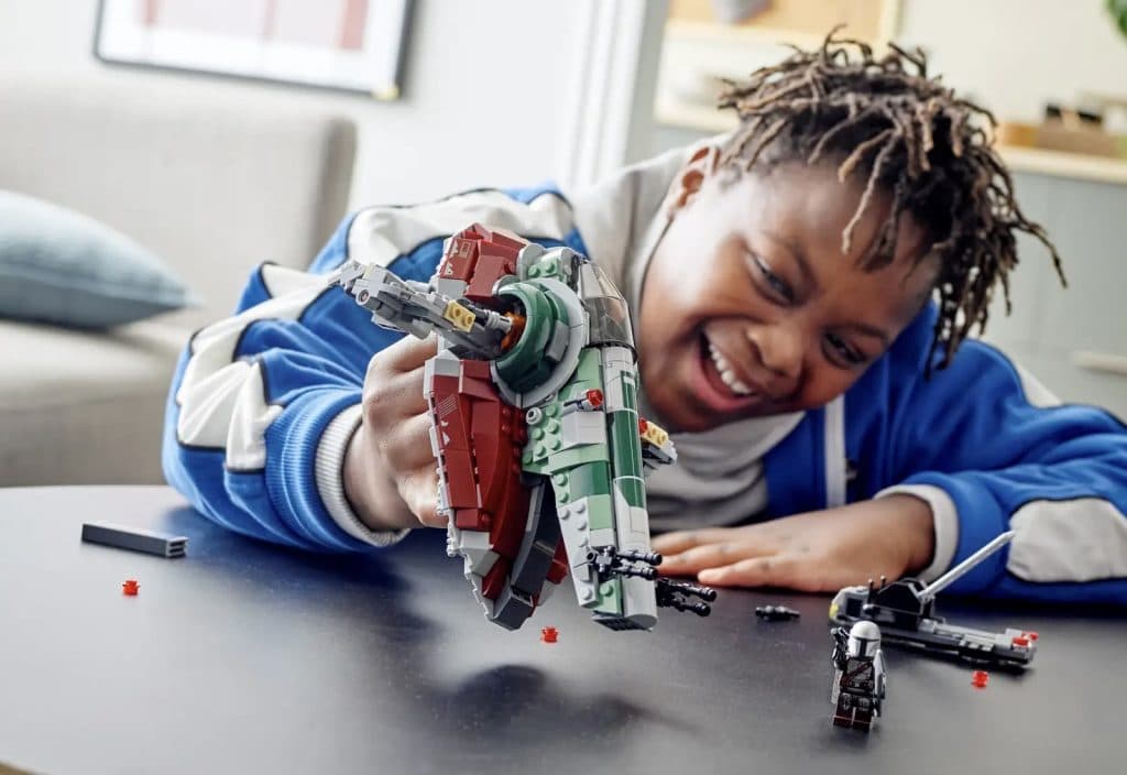 Child playing with the LEGO Star Wars Boba Fett's Starship set.