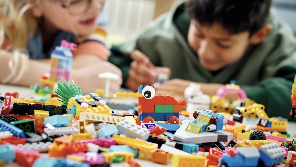Two children building LEGO sets.