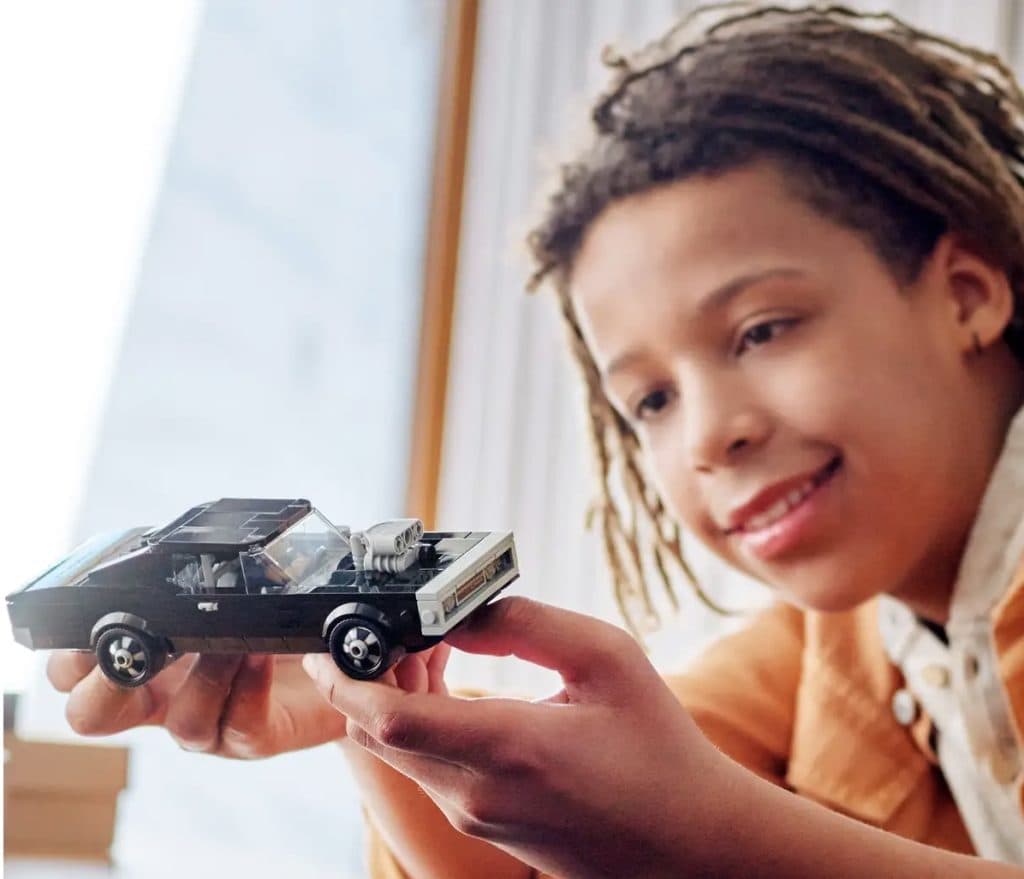 A child playing with the LEGO Speed Champions Dodge Charger from Fast & Furious.