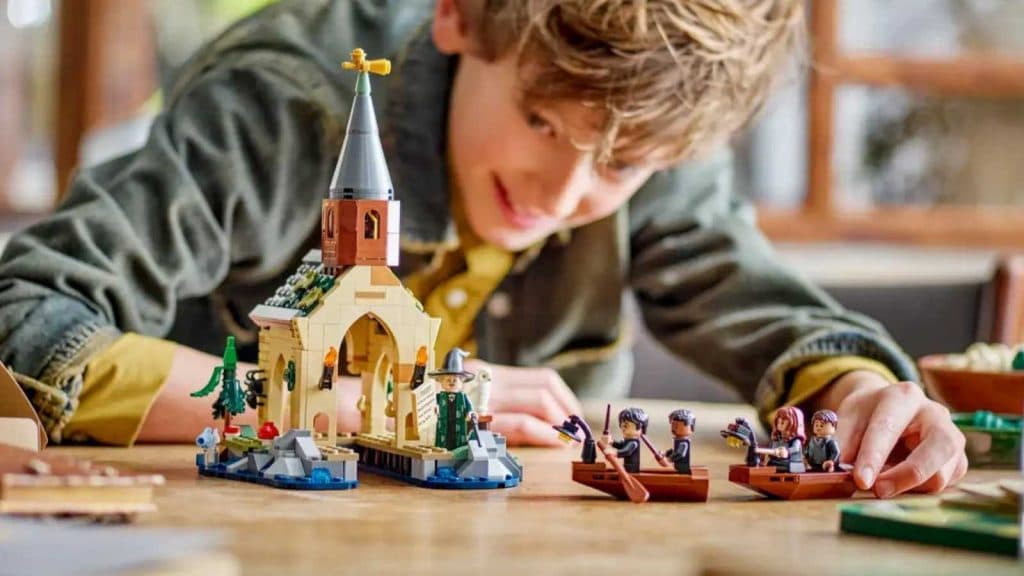 A child playing with the LEGO Harry Potter Hogwarts Castle Boathouse set