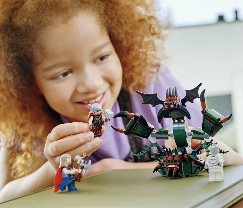 Child playing with the LEGO Marvel Attack on New Asgard set.