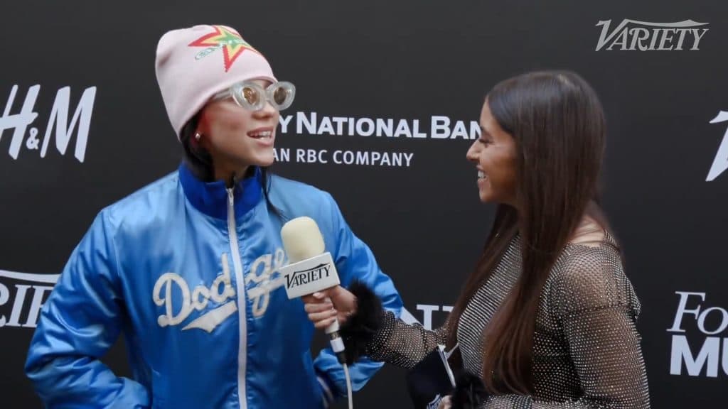 Billie Eilish talking with a reporter on a red carpet