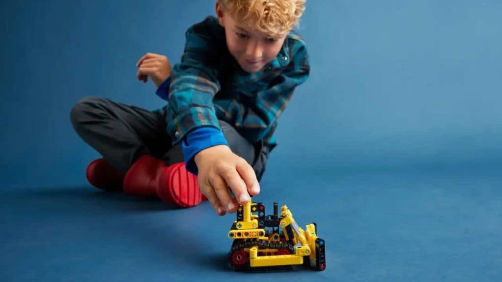 A child playing with the LEGO-reimagined Heavy-Duty Bulldozer.