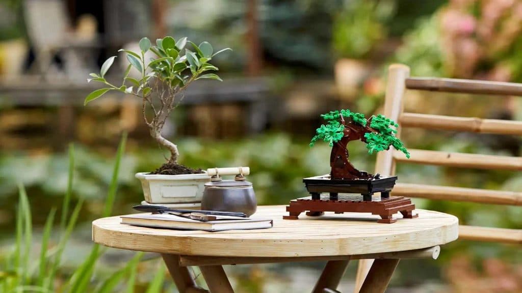 The LEGO-reimagined Bonsai tree next to a real-life Bonsai.