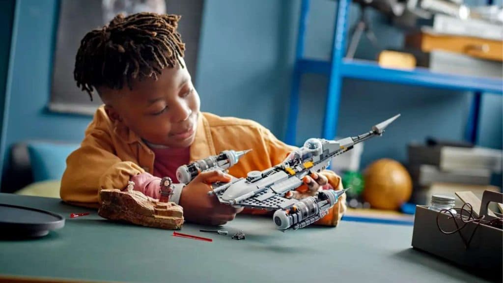 A child playing with the LEGO Star Wars The Mandalorian’s N-1 Starfighter.