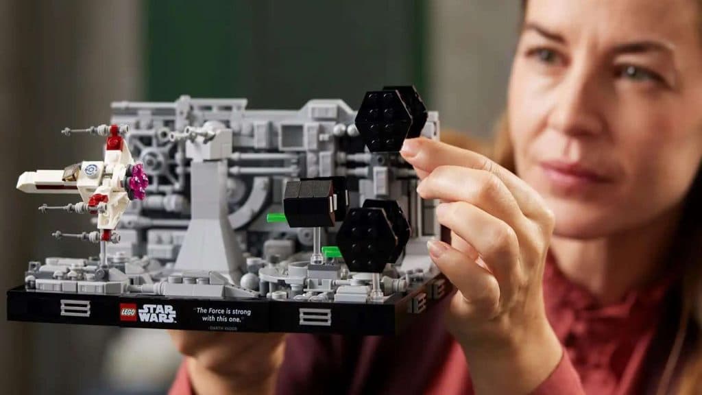An adult admiring their LEGO Star Wars Death Star Trench Run Diorama.