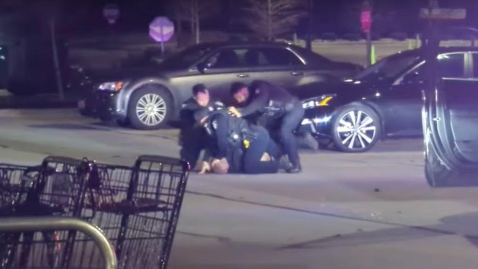 Footage showing three police officers violently arresting a suspect in a parking lot