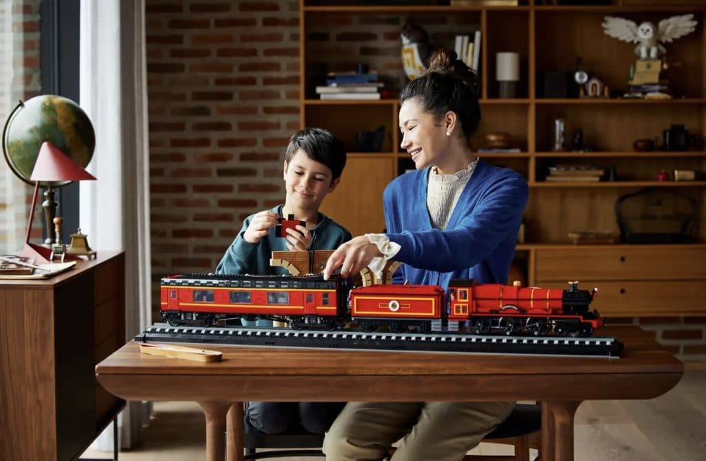 An adult showing their child the LEGO Harry Potter Hogwarts Express - Collectors' Edition.