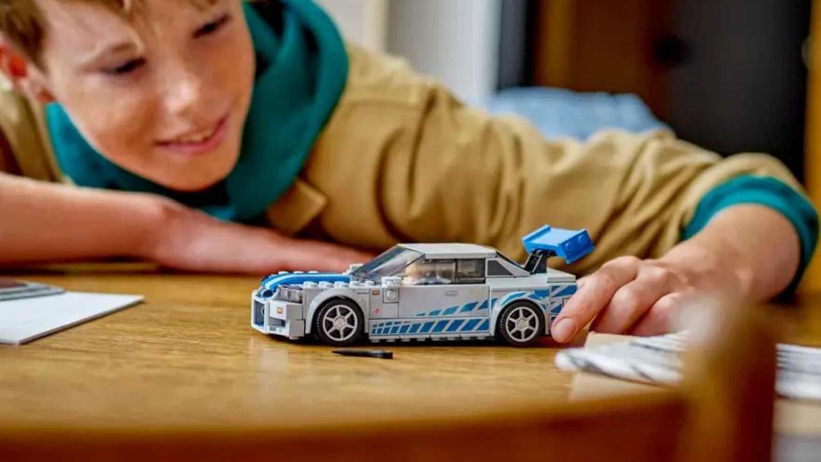 A child with their LEGO Speed Champions 2 Fast 2 Furious Nissan Skyline GT-R