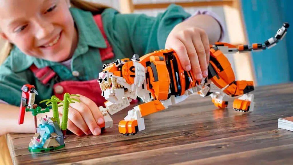 A child playing with their LEGO Creator 3in1 Majestic Tiger set