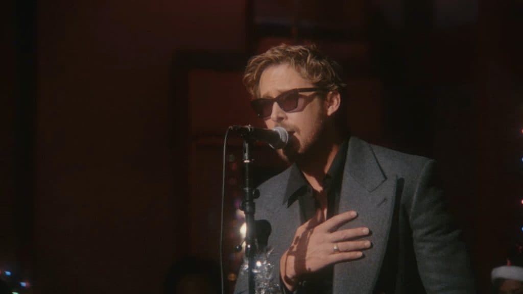 Ryan Gosling performing behind a microphone in new Christmas video