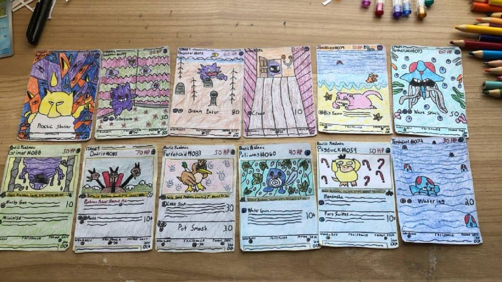 A collection of custom Pokemon TCG cards are laid out on a desk