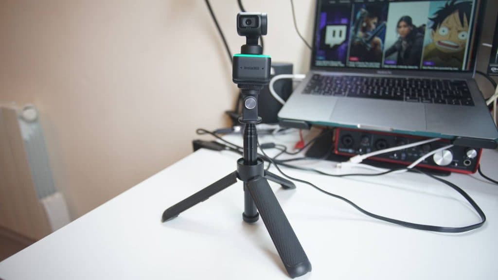 The Insta360 Link webcam is placed in a tripod on a desk