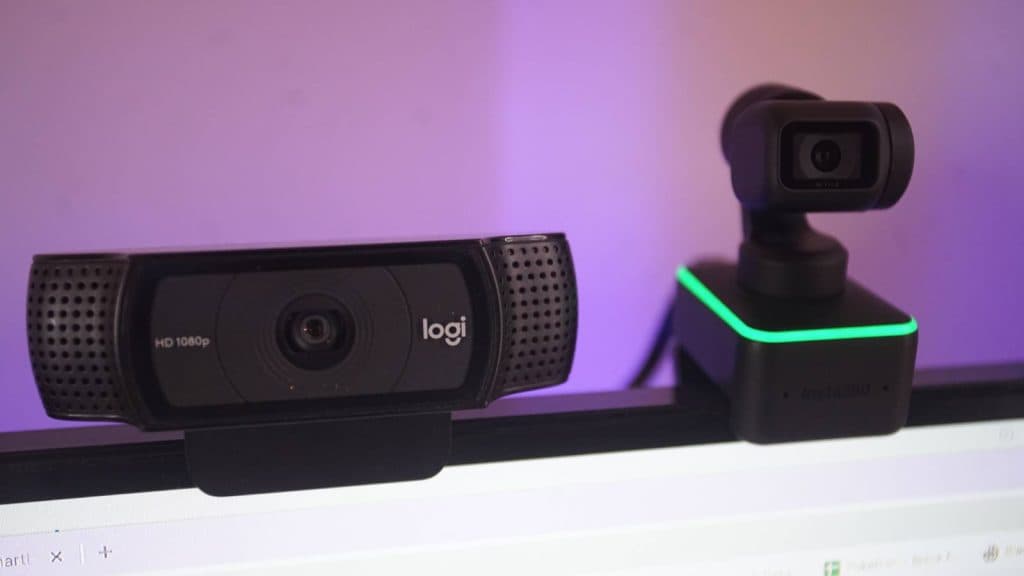 The Insta360 Link webcam is placed on a monitor, next to the Logi 1080