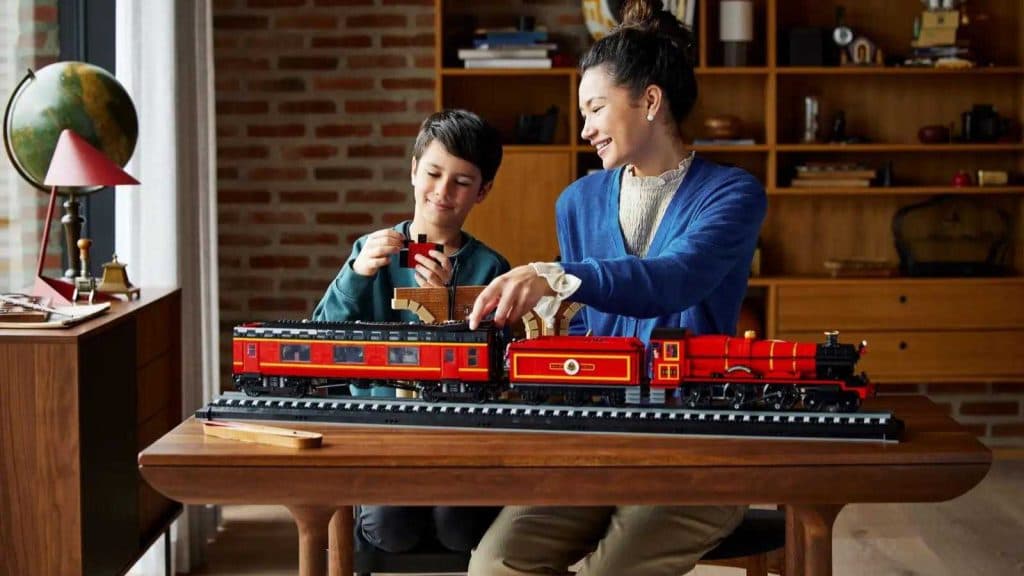 An adult and child with the LEGO Harry Potter Hogwarts Express — Collectors’ Edition set.