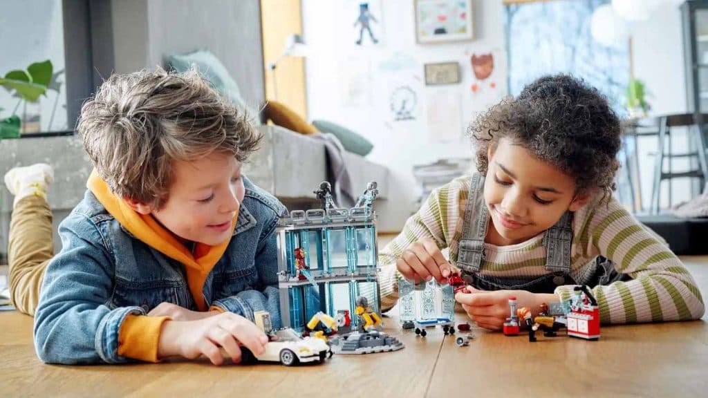 Two children playing with their LEGO Marvel Iron Man Armory set.