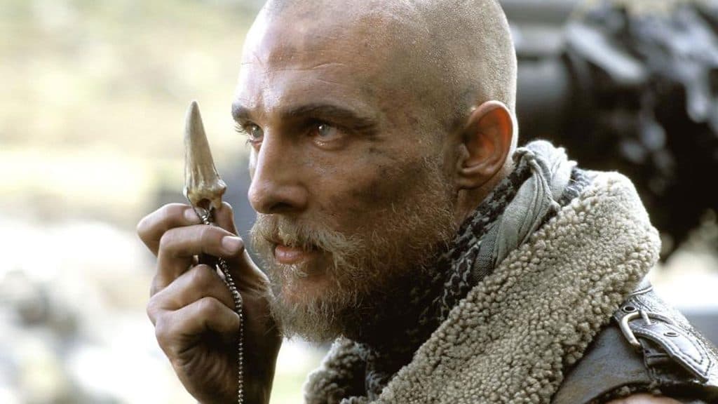 Matthew McConaughey holding up a dragon's tooth in Reign of Fire.