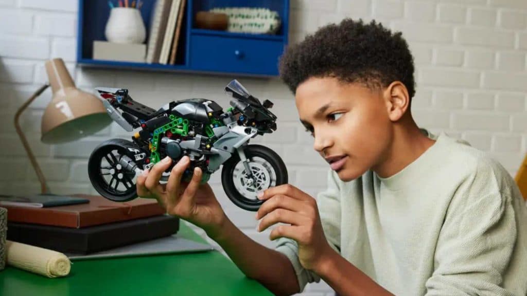 A child admiring their LEGO Technic Kawasaki Ninja H2R Motorcycle set
