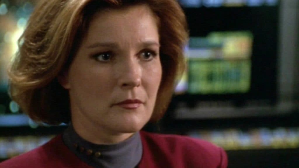 Captain Kathryn Janeway stands on the bridge of the USS Voyager.