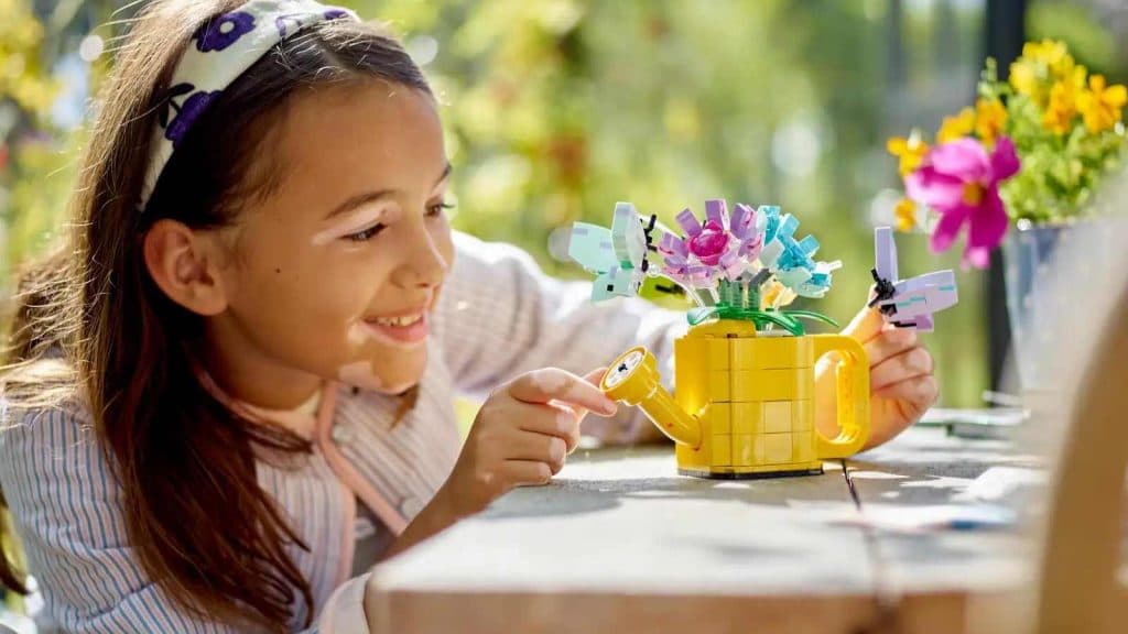 A child admiring their LEGO Creator 3in1 Flowers in Watering Can