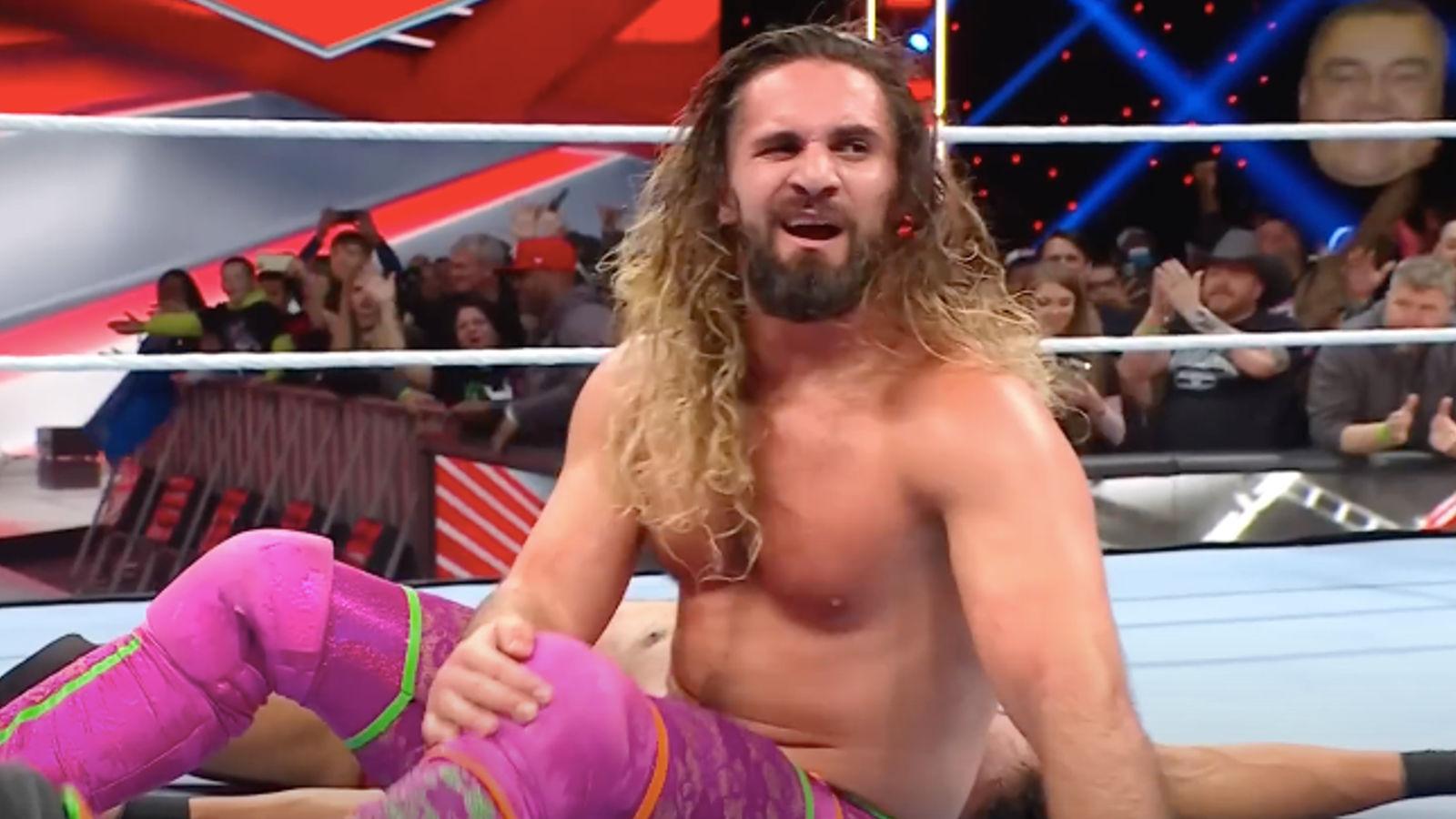 Seth Rollins clutches his knee.