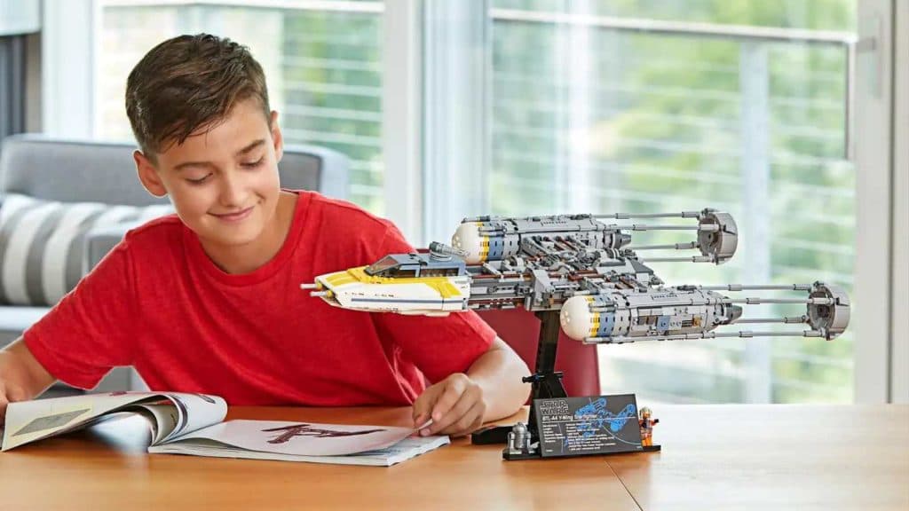 A teen with their LEGO Star Wars Y-Wing Starfighter set