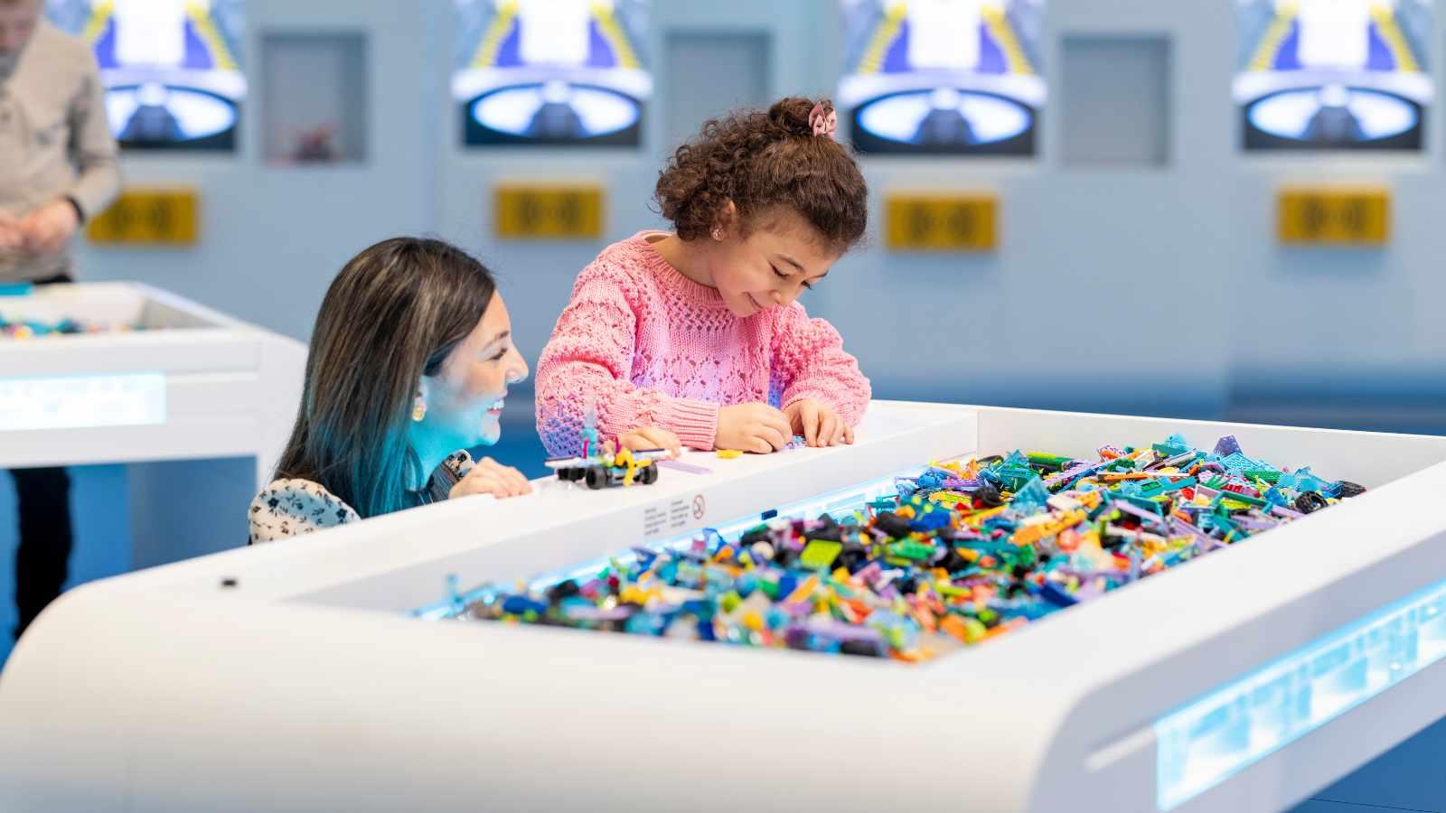 Two children playing with LEGO bricks at the LEGO House's new experience.