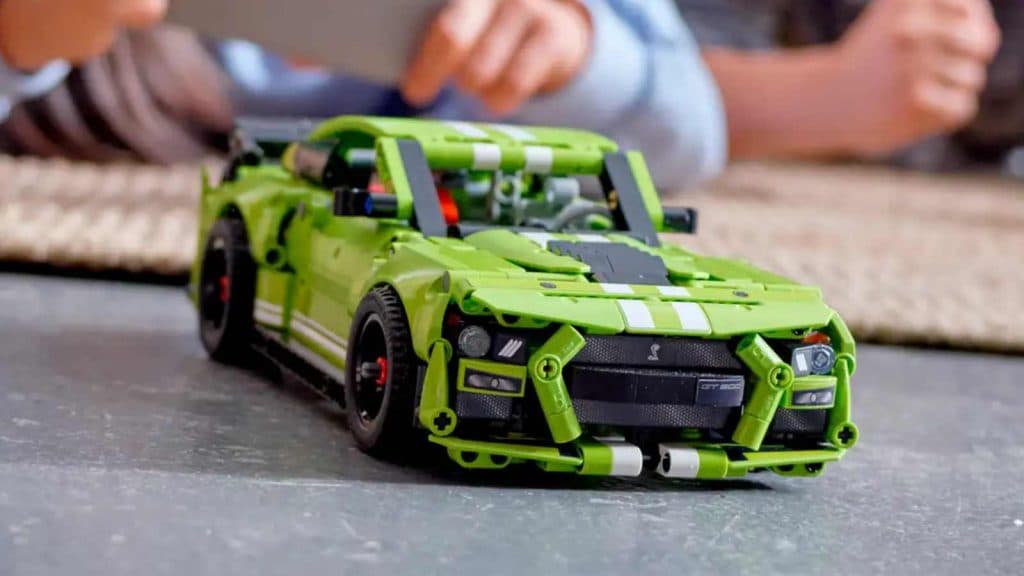 Two children playing with the LEGO-reimagined Ford Mustang Shelby GT500