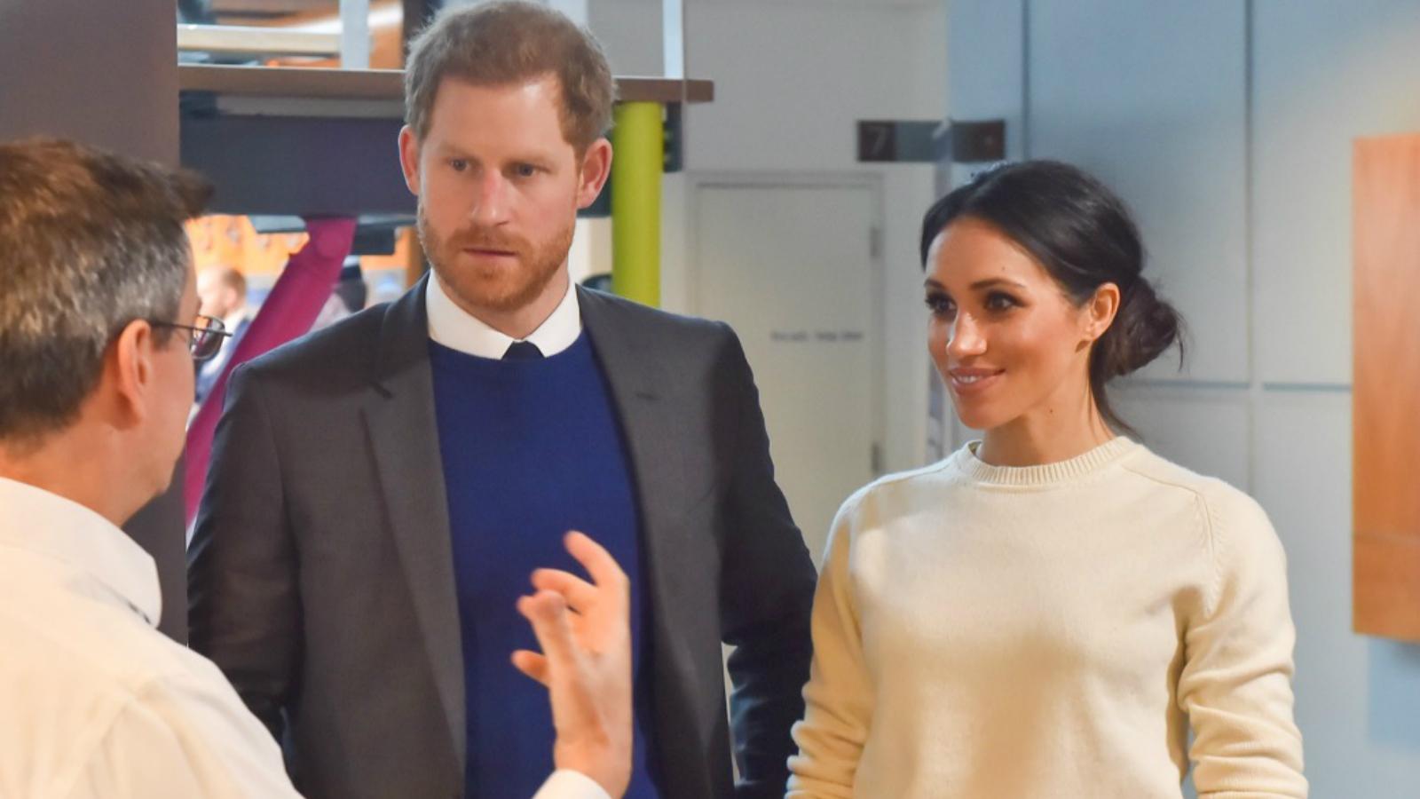 Prince Harry and Meghan Markle talking to a man at a science clinic on a Royal visit