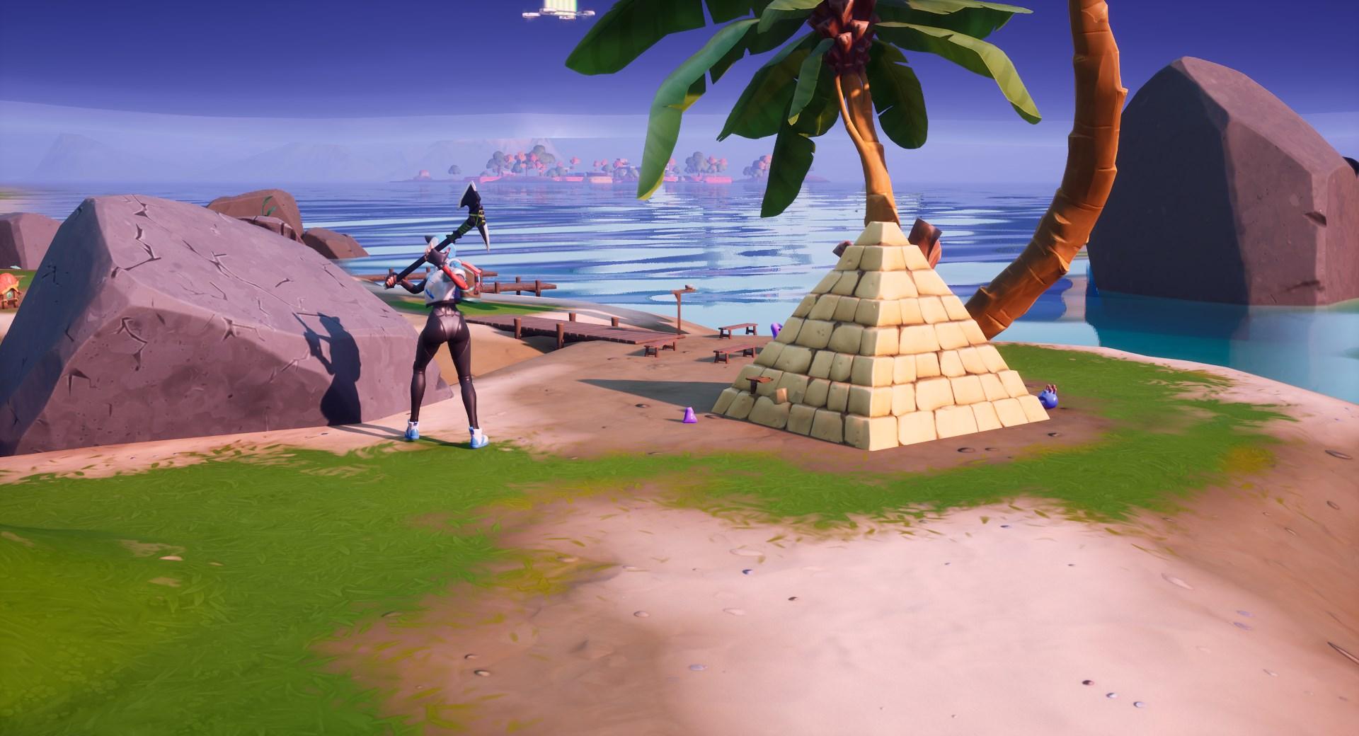 A Fortnite player breaking stone beside the Coral Buddies' pyramid.