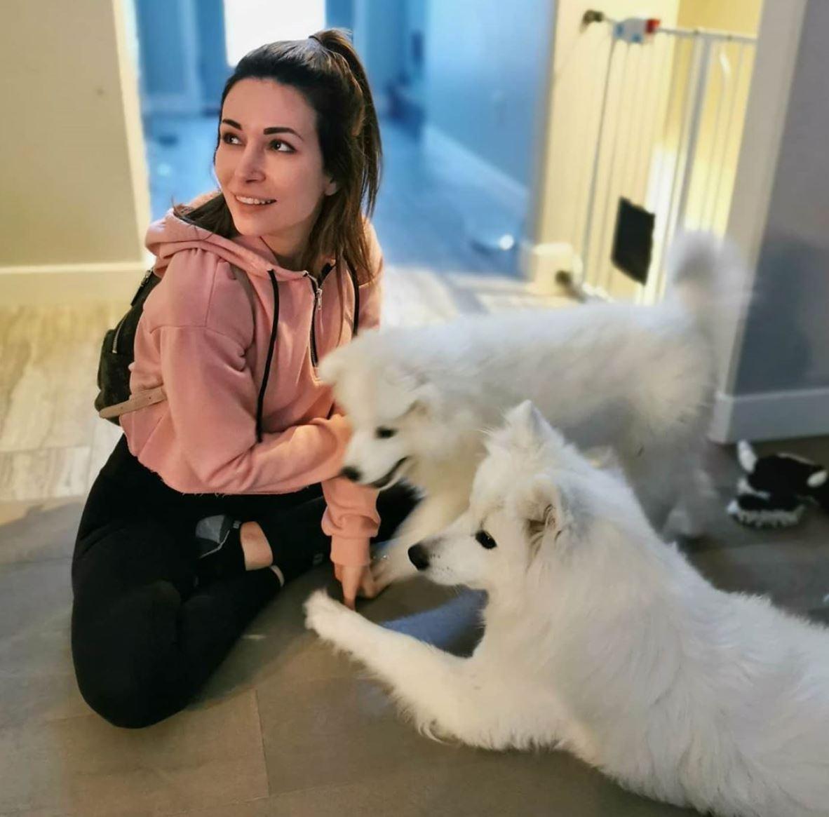 Alinity poses with her two Samoyed pups.