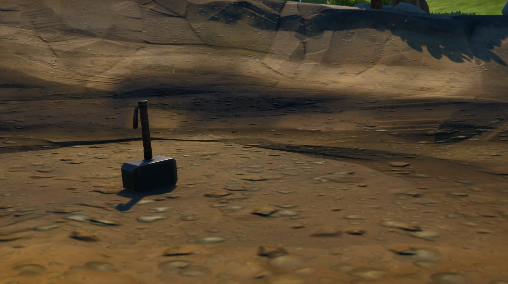 Thor's Hammer in a crater in Fortnite.