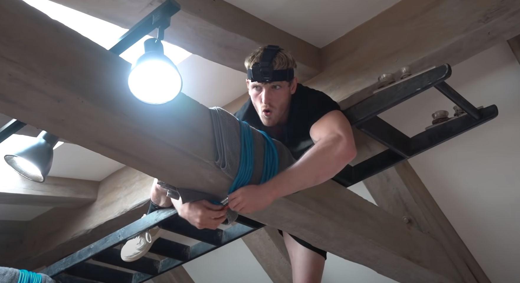 Logan Paul secures a bungee cord to a beam on his ceiling - just before he accidentally took out a lamp.