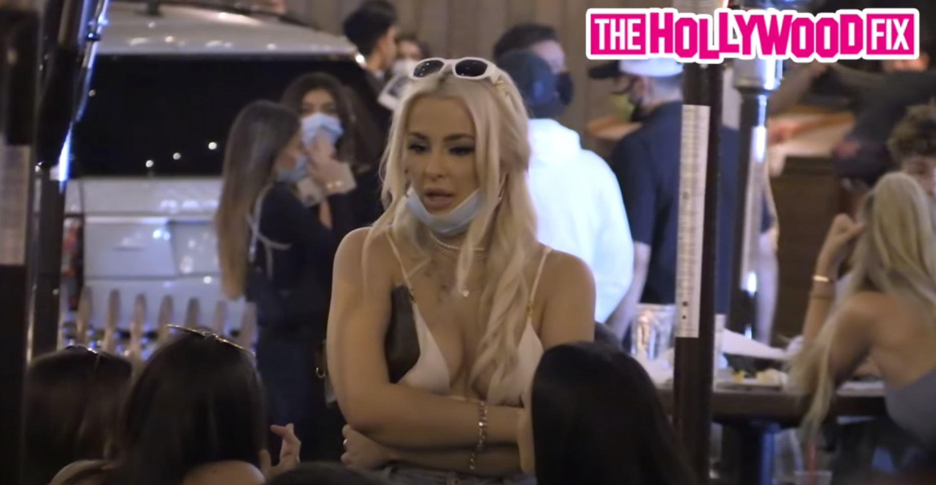 Tana Mongeau talks to friends while out at dinner.