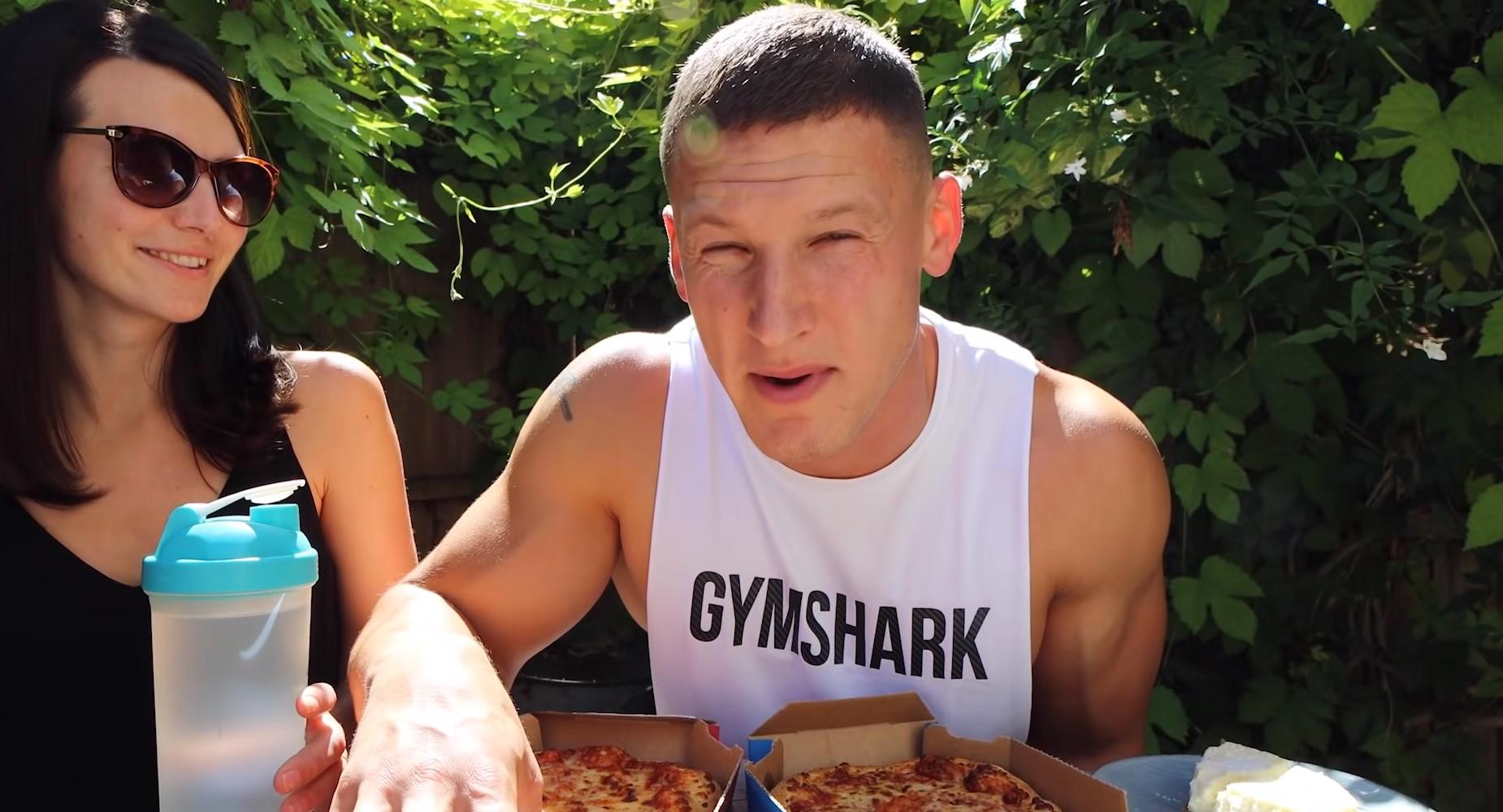 MattDoesFitness eating two Dominos pizzas.