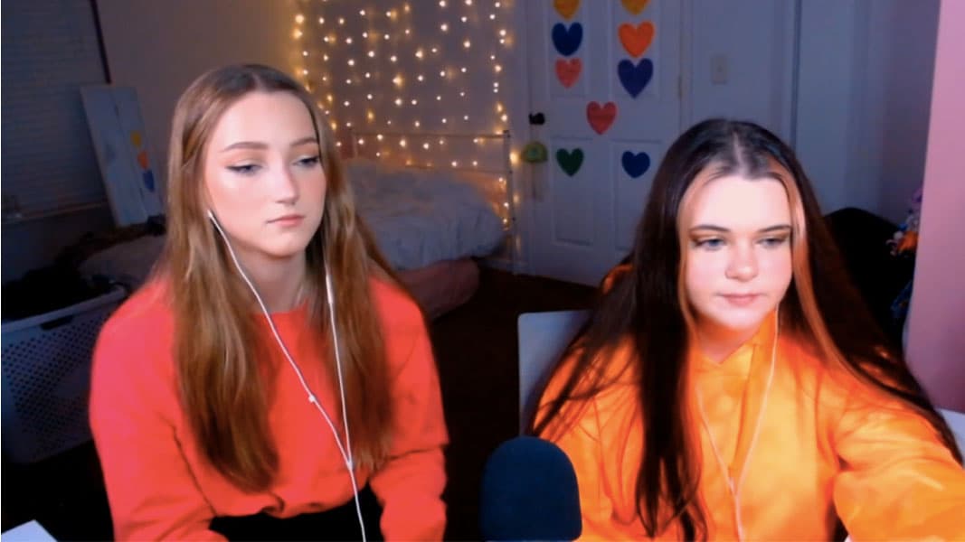 Two girls sat on stream talking to a camera
