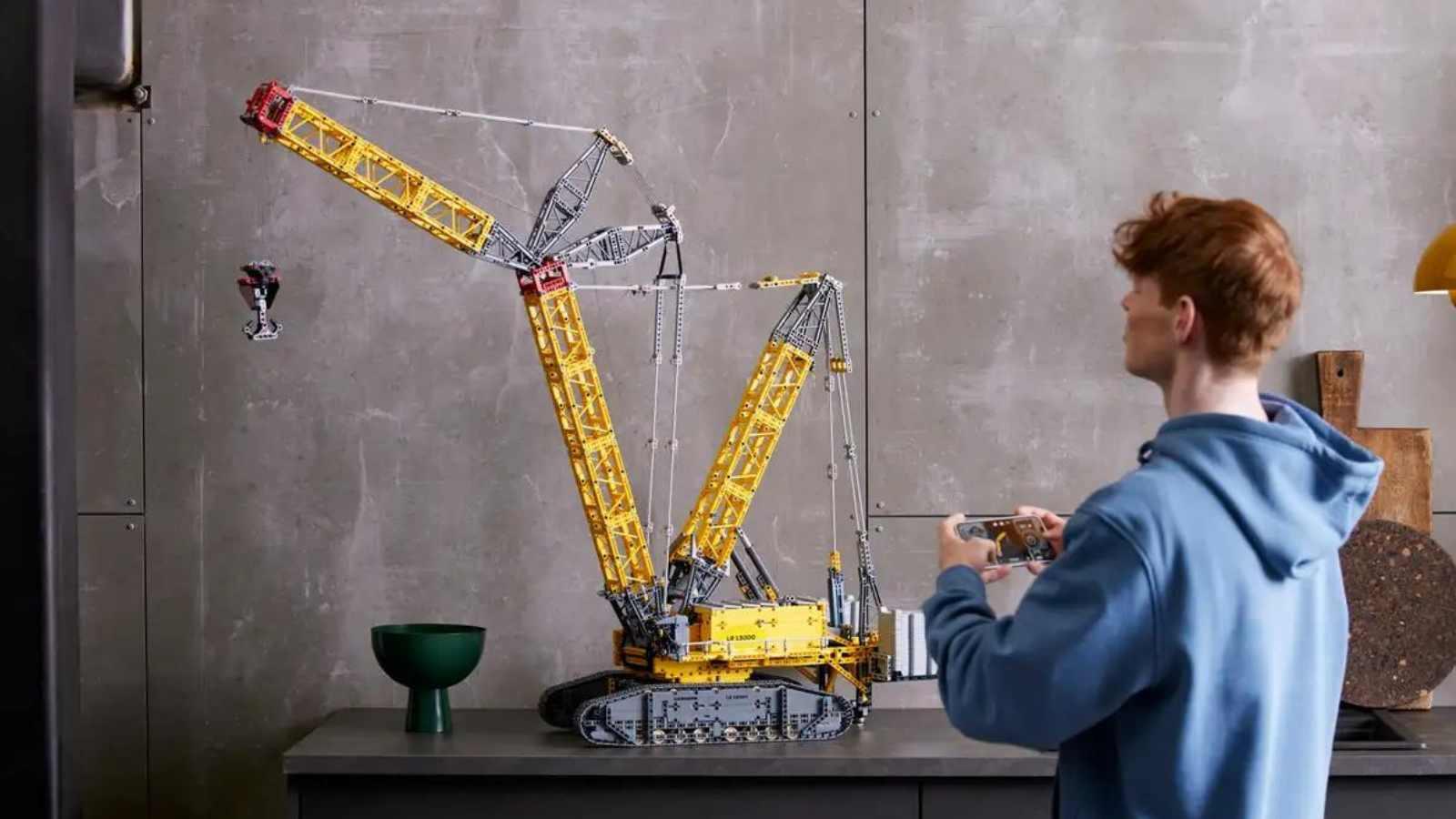 An adult with their LEGO Technic Liebherr Crawler Crane set