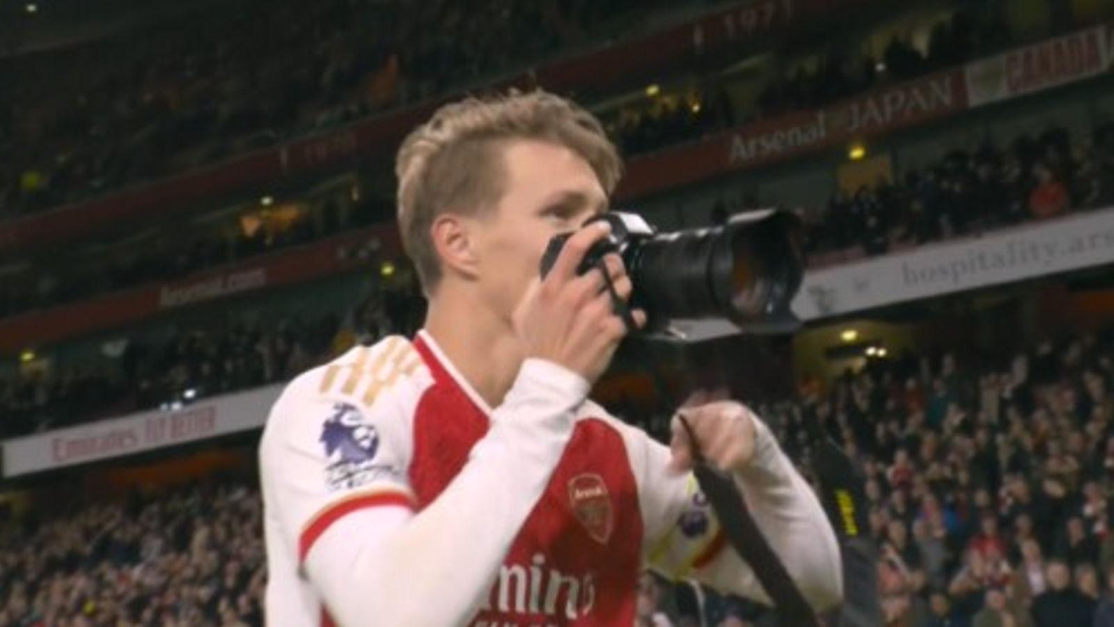Arsenal star Martin Odegaard takes a photo after the Gunners' win over Liverpool