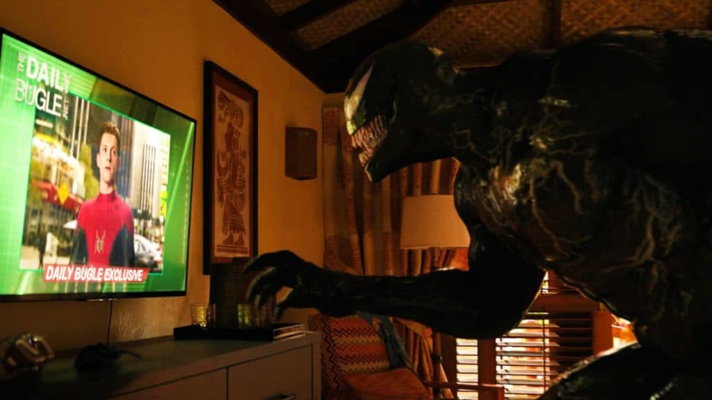 Venom stares at Tom Holland's Spider-Man on the television.