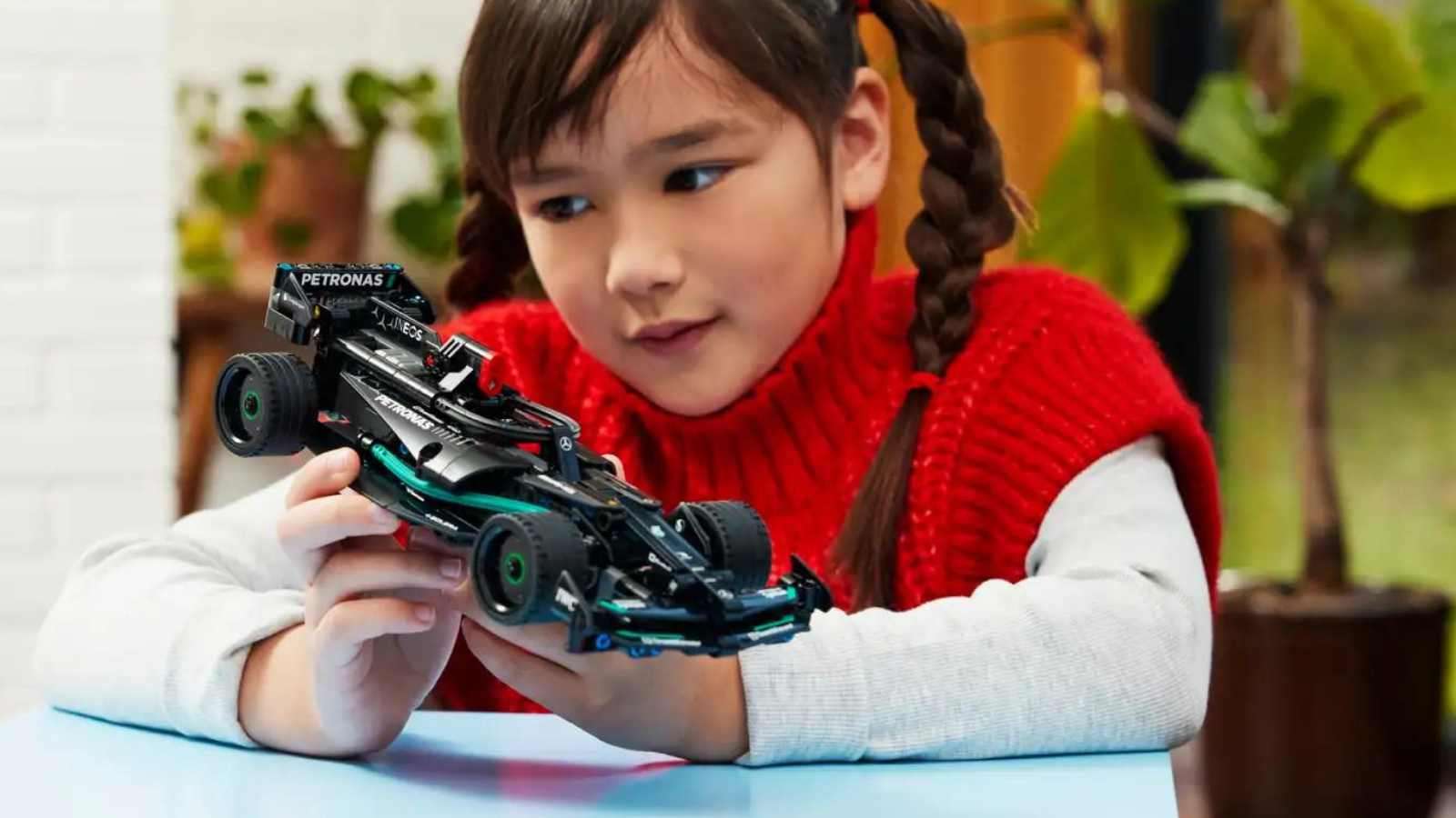 A child admiring their LEGO Technic Mercedes-AMG F1 set