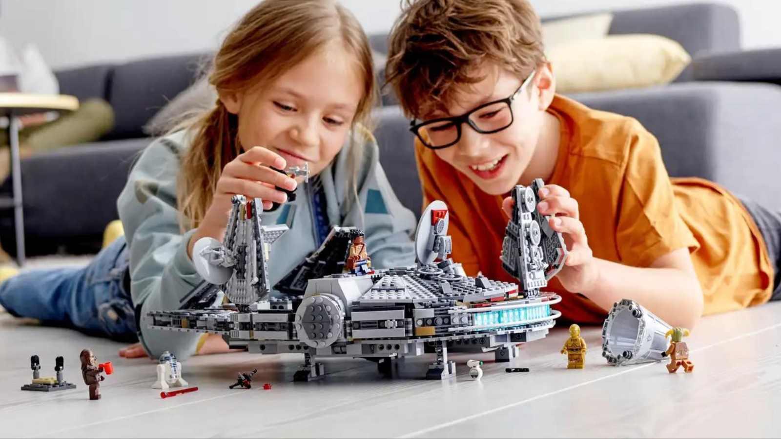 Two kids playing with their LEGO-reimagined Millennium Falcon