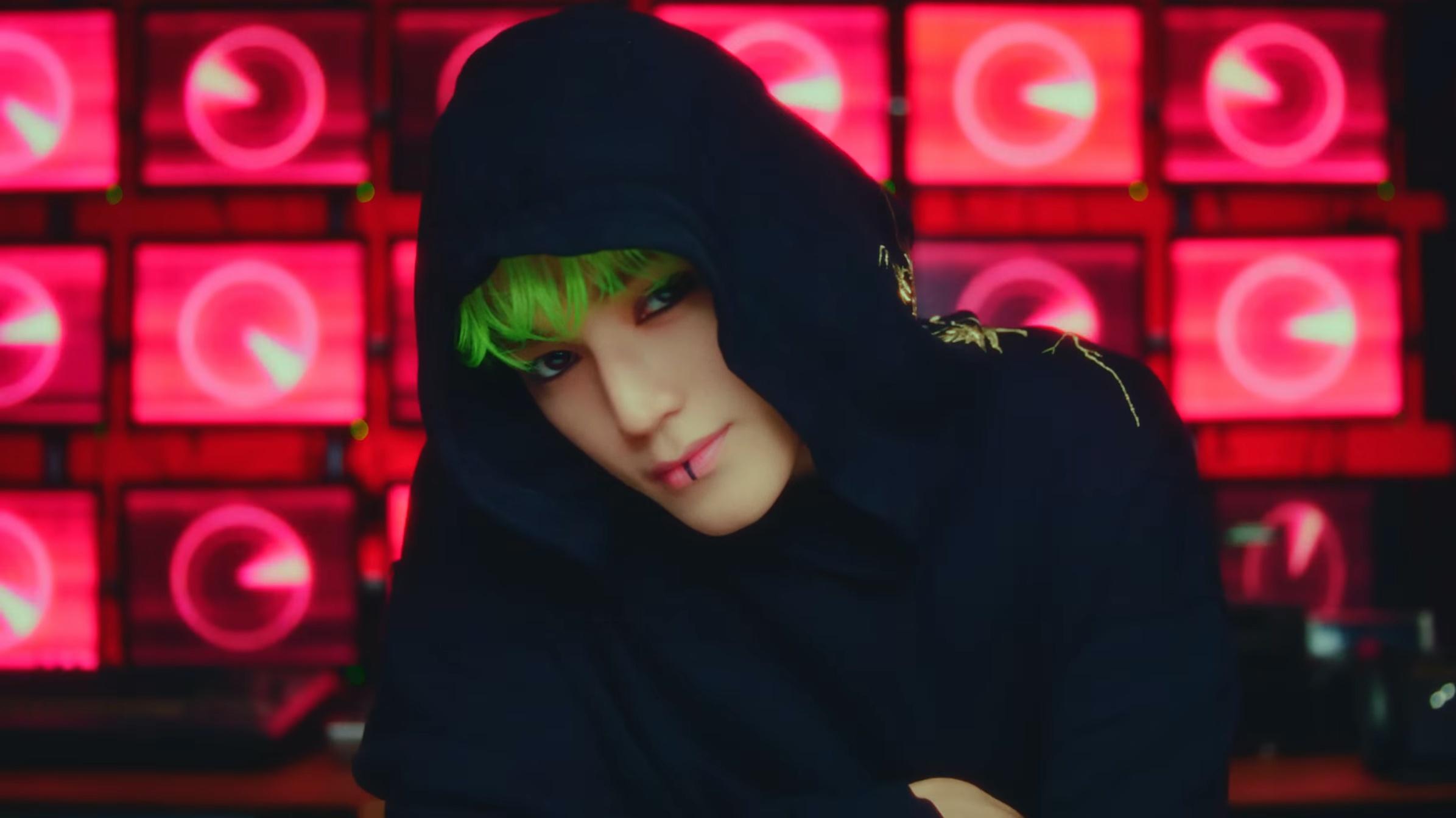 Taeyong with green hair and wearing a black hoodie in 'SHALALA' video