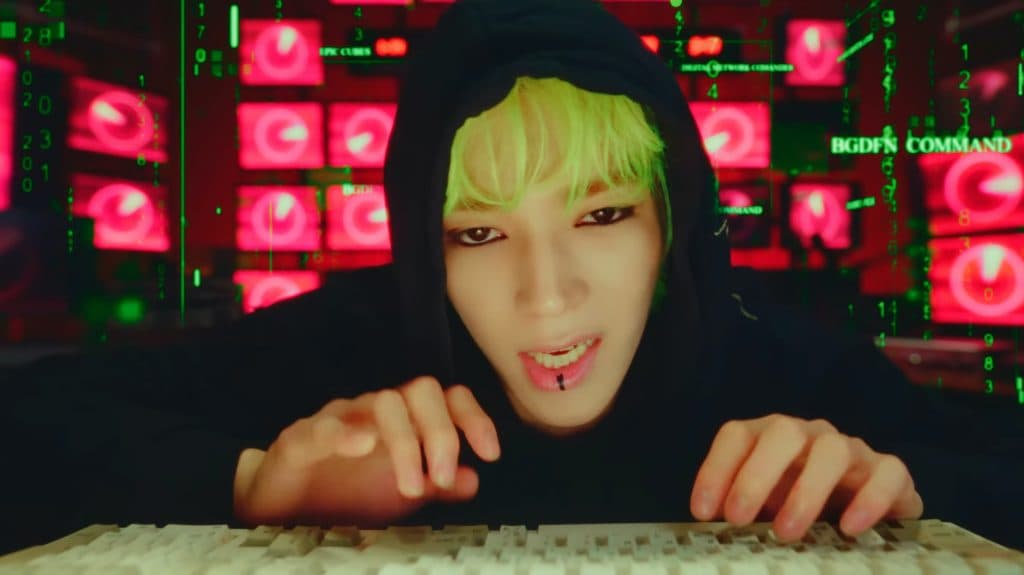 Taeyong with green hair and wearing a black hoodie in his 'SHALALA' video