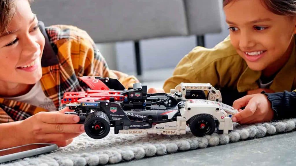 Two children with the LEGO-reimagined Formula E Porsche 99X Electric