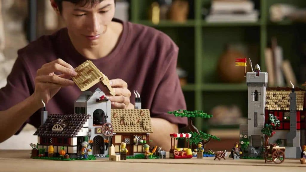 An adult building their LEGO Icons Medieval Town Square set