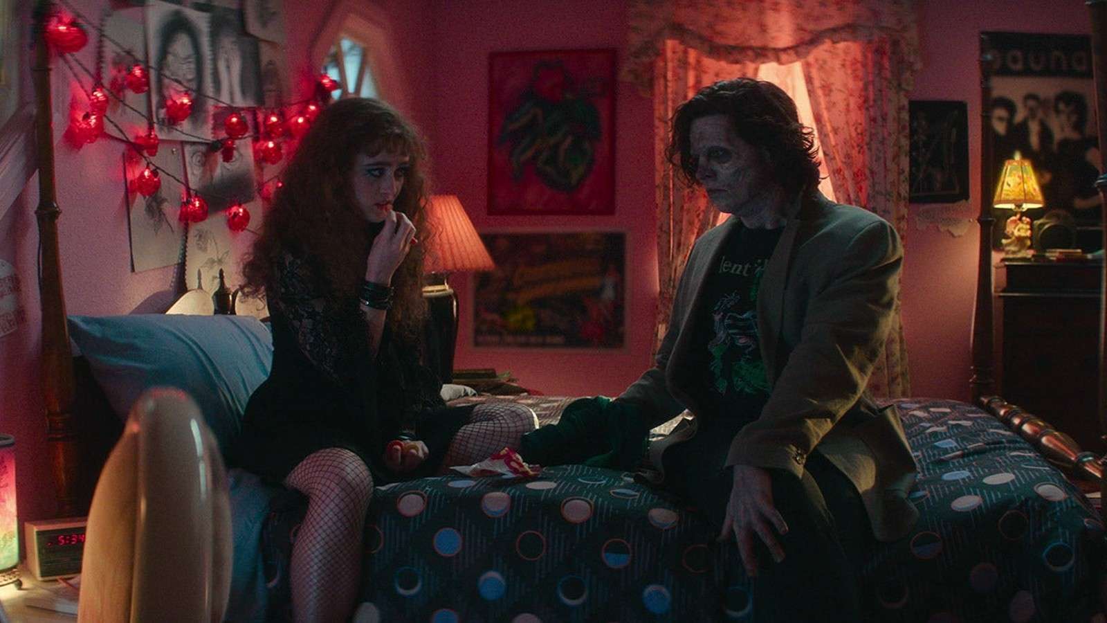 Kathryn Newton and Cole Sprouse sitting on a bed in Lisa Frankenstein.