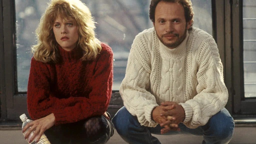 Harry and Sally crouch down while looking at a rug.
