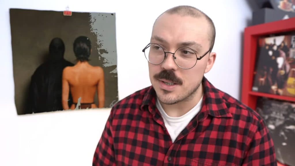 YouTube music critic Anthony Fantano wearing a flannel shirt while reviewing a Kanye West album